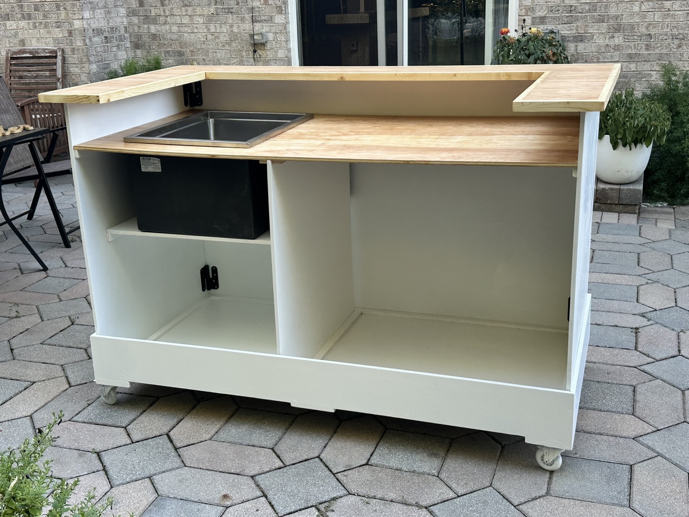Mobile bar cart with butcher-block top, built-in sink and ice chest, on heavy-duty casters