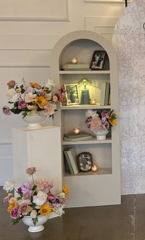 Arched display shelf styled with florals for an event
